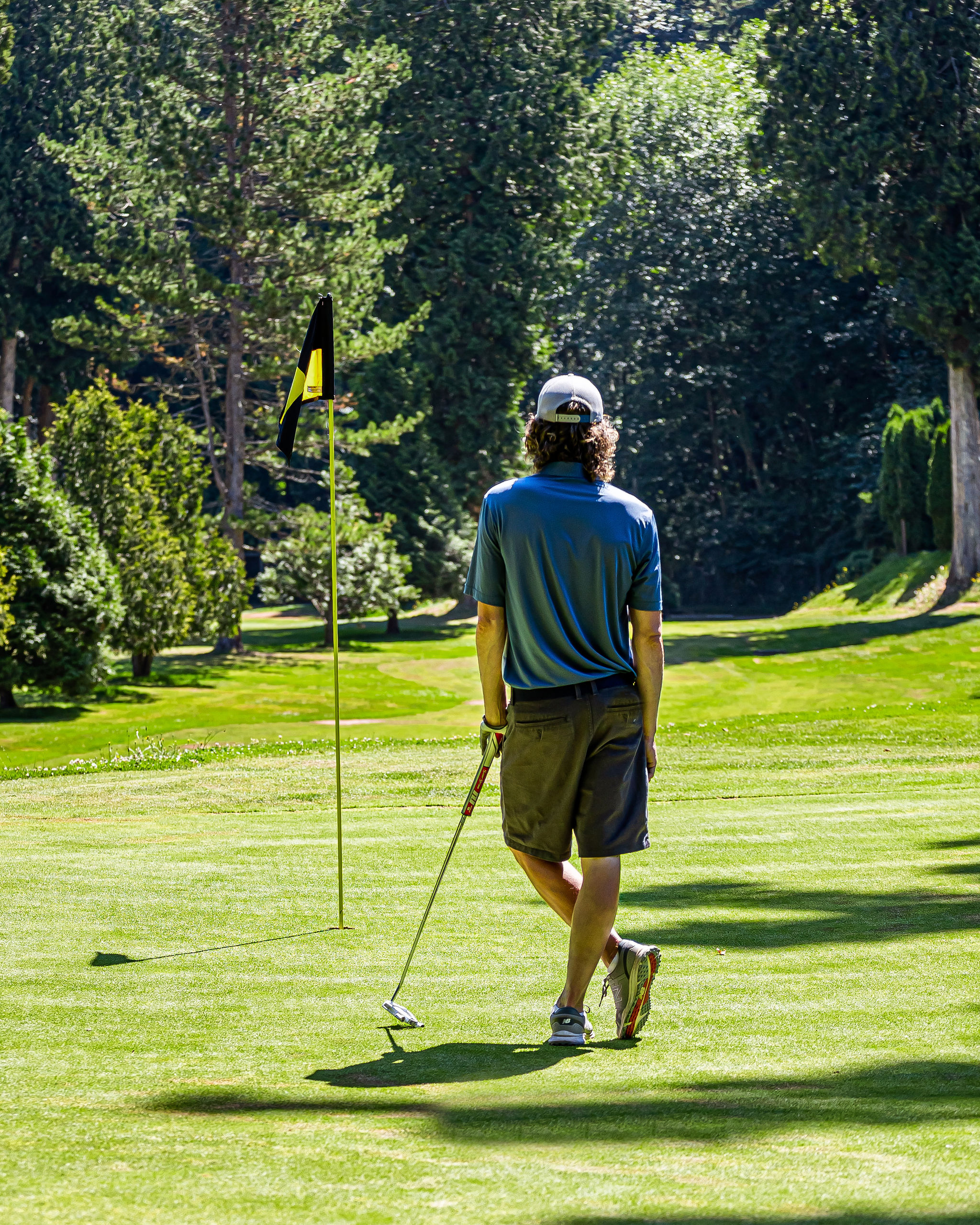 person with a putter looking at the hole and flag - Meridian Hills - Surrey BC